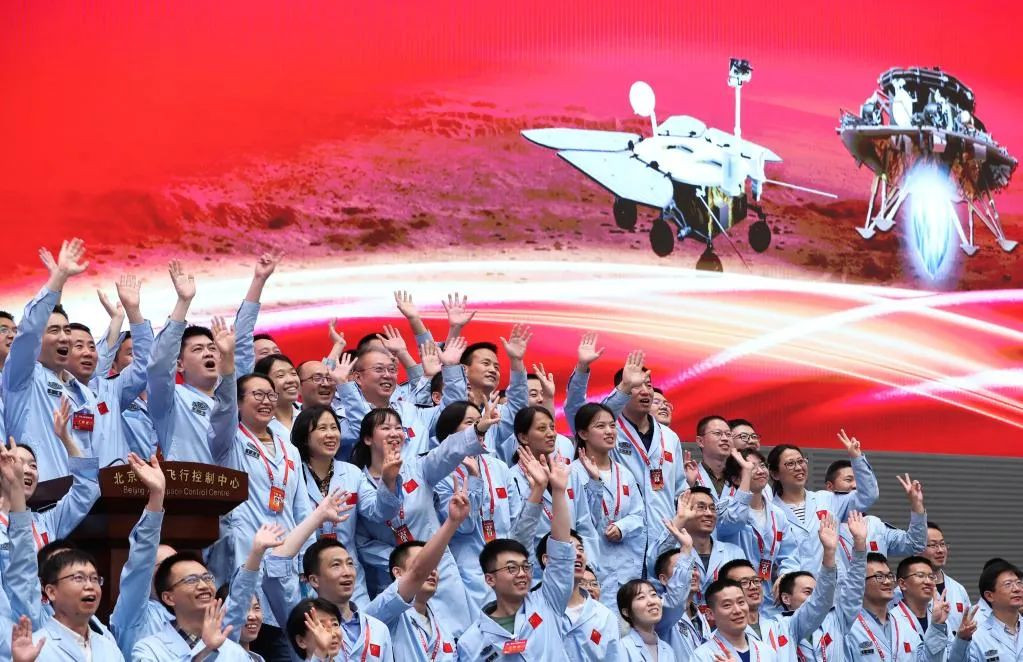 航天科研人员在北京航天飞行控制中心指挥大厅庆祝我国首次火星探测任务着陆火星成功。 